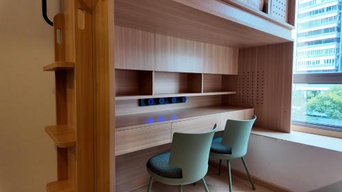 een keuken met 2 stoelen, een aanrecht en een raam bij HOMIX Hotel in Singapore