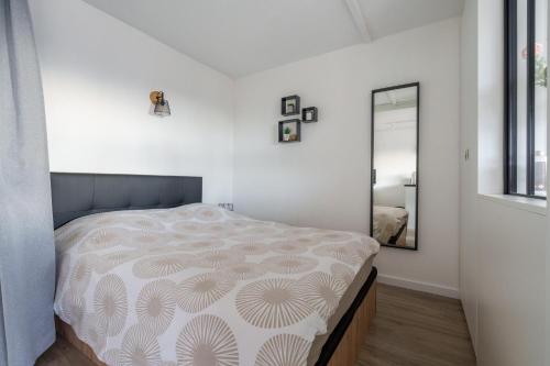 une chambre avec un lit et un miroir dans l'établissement La Résidence Le Belvédère - Avec Balcon, à Le Tholy