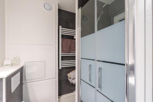 une salle de bains avec une armoire vitrée contenant un chien dans l'établissement La Résidence Le Belvédère - Avec Balcon, à Le Tholy