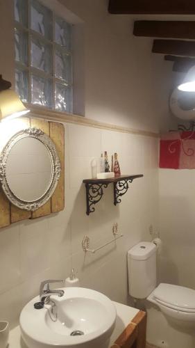 a bathroom with a sink and a mirror and a toilet at Casa La Arracada in Villena