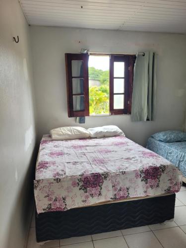 una camera da letto con un letto e una finestra di Sítio Guanabara a Guaramiranga