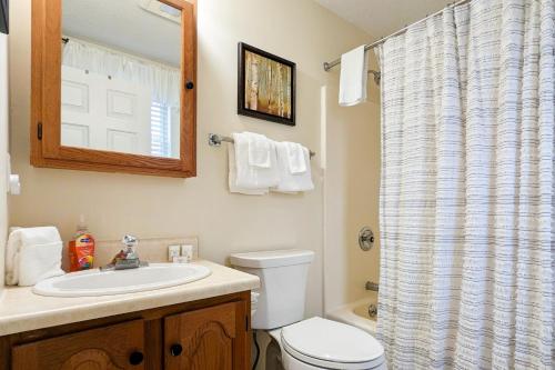 um banheiro com vaso sanitário, pia e espelho em Dream Weaver em Ludlow