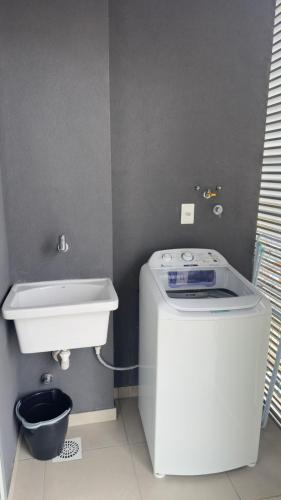 a small bathroom with a toilet and a sink at Loft Central com garagem in Pelotas