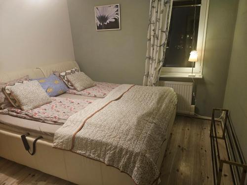a small bedroom with a bed with a window at Malmoxie Unic Garden House in Oxie