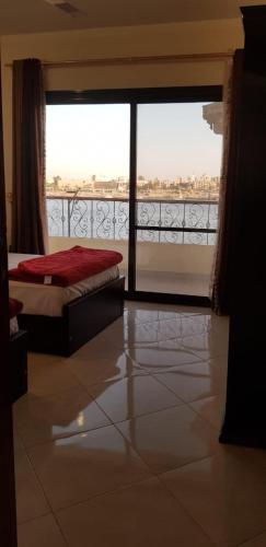 a bedroom with a bed and a large glass window at El BOB HOUSE in Luxor
