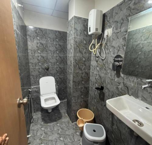 a bathroom with a toilet and a sink at Hotel meghshyam in Sānand