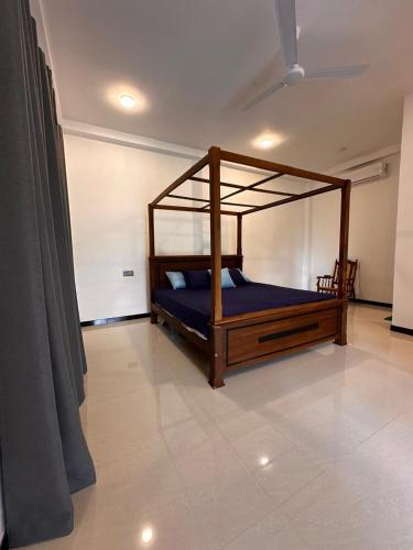a bedroom with a bed with a wooden frame at The Regent Villa in Unawatuna
