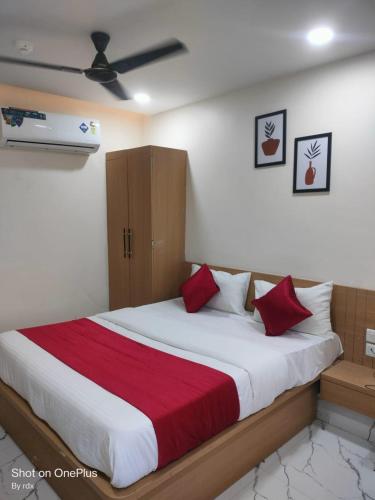 a bedroom with a large bed with red pillows at Hotel meghshyam in Sānand