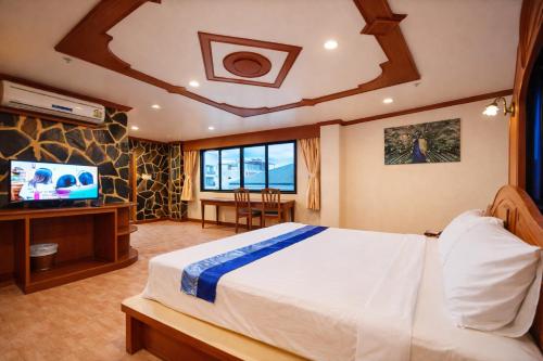een slaapkamer met een bed en een flatscreen-tv bij Tiger Complex Hotel in Patong Beach