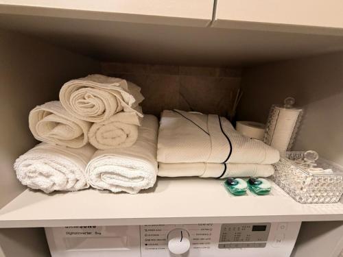 a pile of towels sitting on a shelf at Ūla Apartments in Mažeikiai