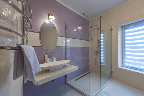 een badkamer met een wastafel en een spiegel bij Dvorik Leva in Truskavets