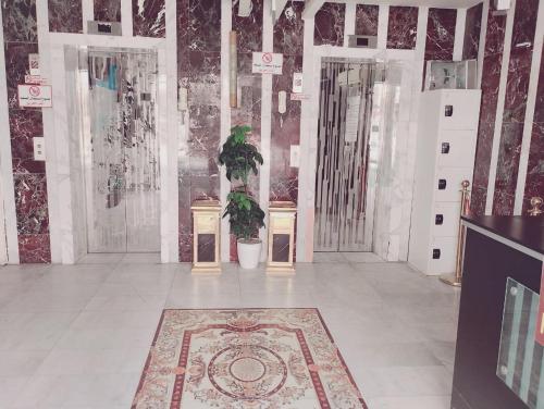 een kamer met twee toegangsdeuren en een vloerkleed bij فندق الواحة الماسية 2 in Quai