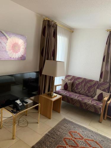 een woonkamer met een bank en een tafel bij Cozy Studio with Wellness in Goms in Blitzingen