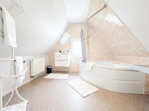 a white bathroom with a tub and a sink at Chic&Cosy - Vue exceptionnelle - Centre Haguenau in Haguenau