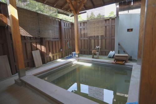 an indoor swimming pool in a building with a wooden wall at 民泊の枠を超えた民泊セカンドライフ in Kashima