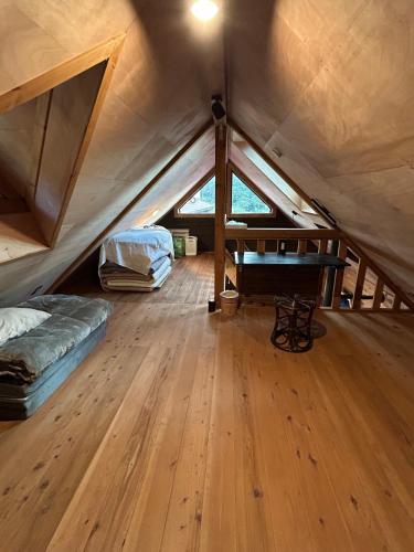 a room with a bed and a piano in a attic at 民泊の枠を超えた民泊セカンドライフ in Kashima