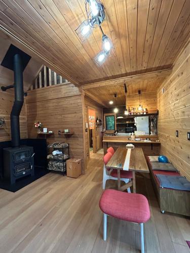 a living room with a wooden ceiling and a stove at 民泊の枠を超えた民泊セカンドライフ in Kashima