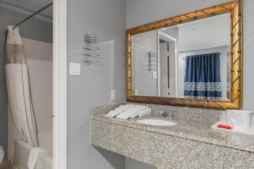 un bagno con lavandino e specchio di Golden Inn Dallas by Hotel O a Dallas