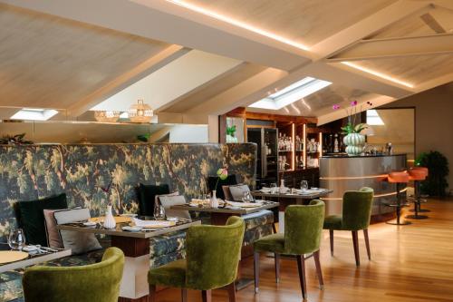 a dining room with tables and green chairs at Palazzo Venezia in Como