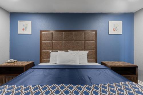 una camera da letto con un letto grande con pareti blu di Golden Inn Dallas by Hotel O a Dallas