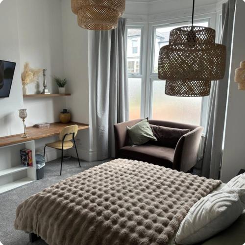 een slaapkamer met een bed, een stoel en een bureau bij Norton Rd Guest House in Stockton-on-Tees