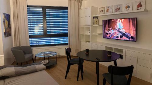 een woonkamer met een tafel en een tv bij NEW STYLISH APARTMENT Varta Alpha 2025 & Parking in Praag