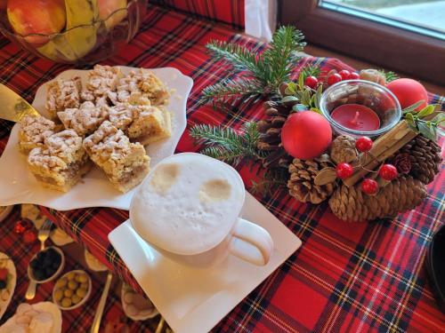 Una mesa con una taza de café y un plato de comida. en Skalny Brzeg, en Czarna Góra