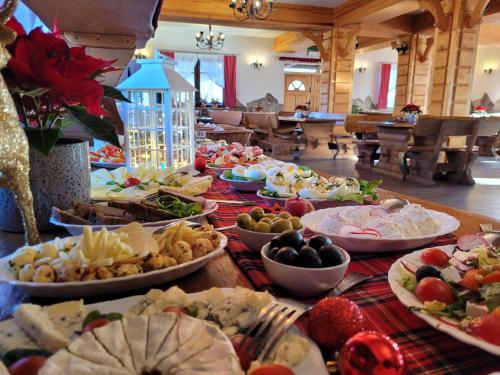 Una mesa larga con muchos platos de comida encima. en Skalny Brzeg, en Czarna Góra