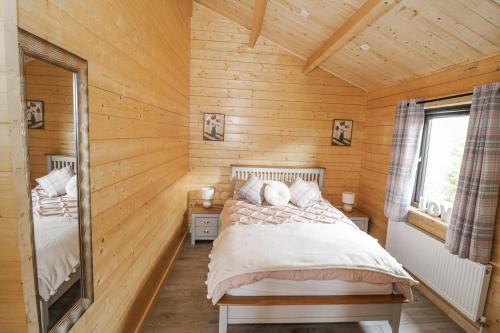 a bedroom with a bed in a wooden cabin at Glenview Log Cabin in Ballycastle