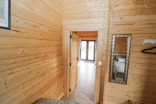 a hallway in a log cabin with a mirror at Glenview Log Cabin in Ballycastle
