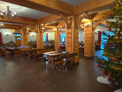 ein Weihnachtsbaum in einem Restaurant mit Tischen und Stühlen in der Unterkunft Skalny Brzeg in Czarna Góra