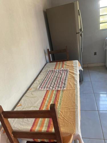 a wooden bed in a room with a refrigerator at Casa Aurora in Chapada dos Guimarães