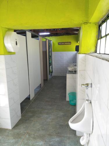 a bathroom with a urinal and a yellow wall at Sirimon Base Camp in Nanyuki