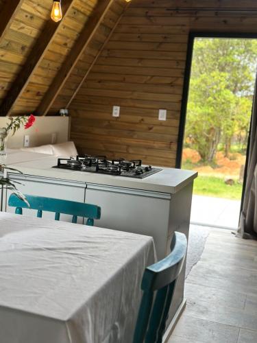 a kitchen with a stove and a table with chairs at Cabana Itapeva Torres in Torres