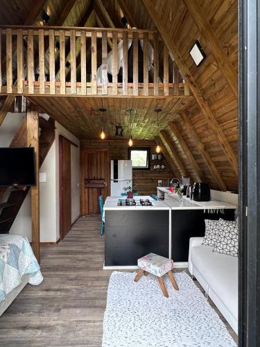 a kitchen and living room in a cabin at Cabana Itapeva Torres in Torres