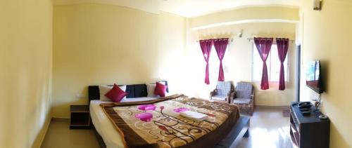 a bedroom with a large bed with red pillows at D'Bonn Inn in Shillong