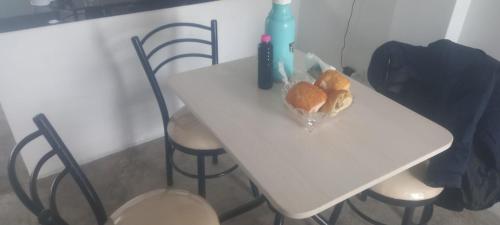a white table with chairs and a basket of bread on it at A y C Hospedaje - Taxi FREE - Airport - Accommodation in Lima