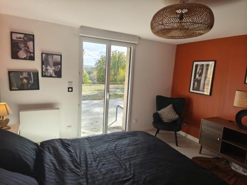 een slaapkamer met een bed en een glazen schuifdeur bij Cocon sensuel - Jaccuzzi et petit déjeuner - Proche Chantilly et Beauvais in Clermont