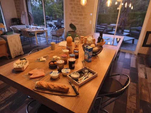 een houten tafel met eten erop bij Cocon sensuel - Jaccuzzi et petit déjeuner - Proche Chantilly et Beauvais in Clermont