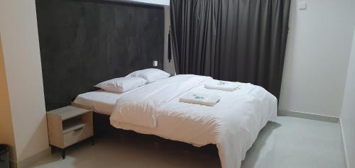 ein Schlafzimmer mit einem Bett, auf dem zwei Handtücher liegen in der Unterkunft Nizwa heart garden home in Nizwa