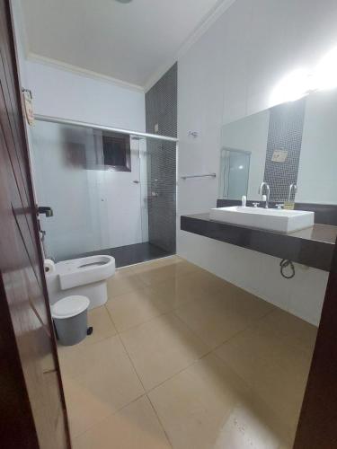 a bathroom with a toilet and a sink at Sítio flor do campo 7L in Sete Lagoas