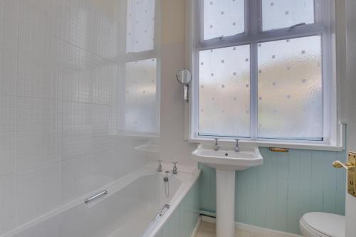 een witte badkamer met een wastafel en een raam bij 3 Bed in Aberystwyth oc-bow115 in Aberystwyth