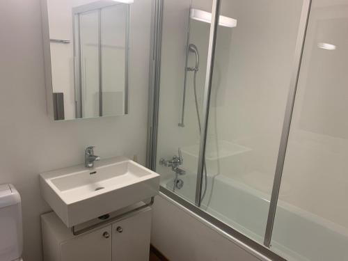 ein weißes Badezimmer mit Waschbecken und Dusche in der Unterkunft Satin Home in Savognin