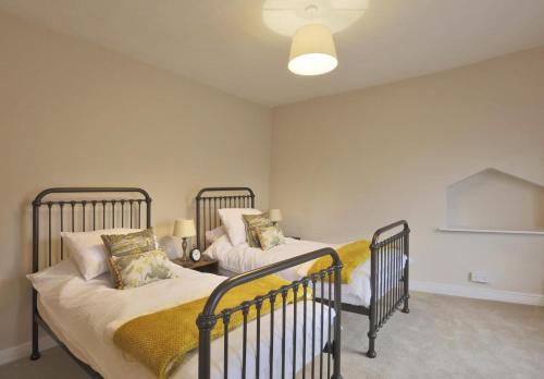 twee eenpersoonsbedden in een kamer met bij 2 Bed in Eye oc-4lamb in Eye