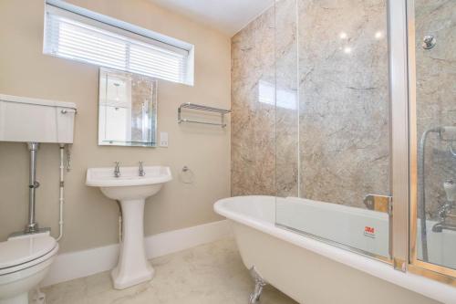 een badkamer met een bad, een toilet en een wastafel bij 2 Bed in Eye oc-4lamb in Eye