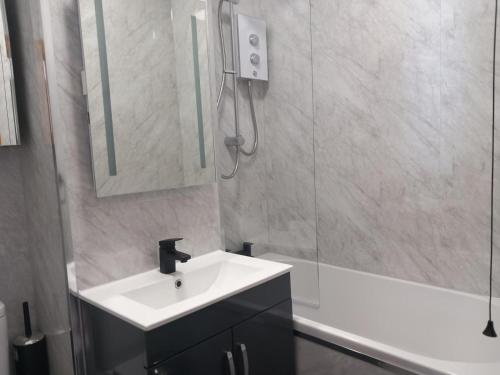 a bathroom with a sink and a mirror and a tub at 2 Bed in Gower oc-hh919 in Bishopston