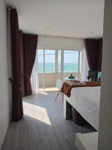 a bedroom with a bed and a view of the ocean at Inuli Coco Hut in Kalutara