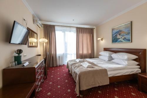 een hotelkamer met een bed en een televisie bij Dvorik Leva in Truskavets