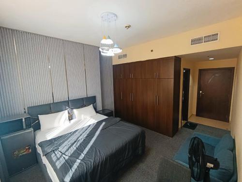 a bedroom with a bed and a chair in it at ApartHotel Rooms in Ajman