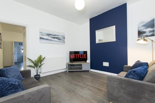 a living room with two couches and a tv at K Suites - Granville Avenue in Long Eaton